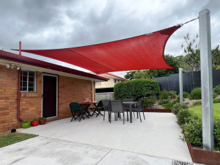 With the installation of this 4-point shade sail in striking Red Earth Z-16 shade cloth, this lovely home now boasts a lovely outdoor living space.